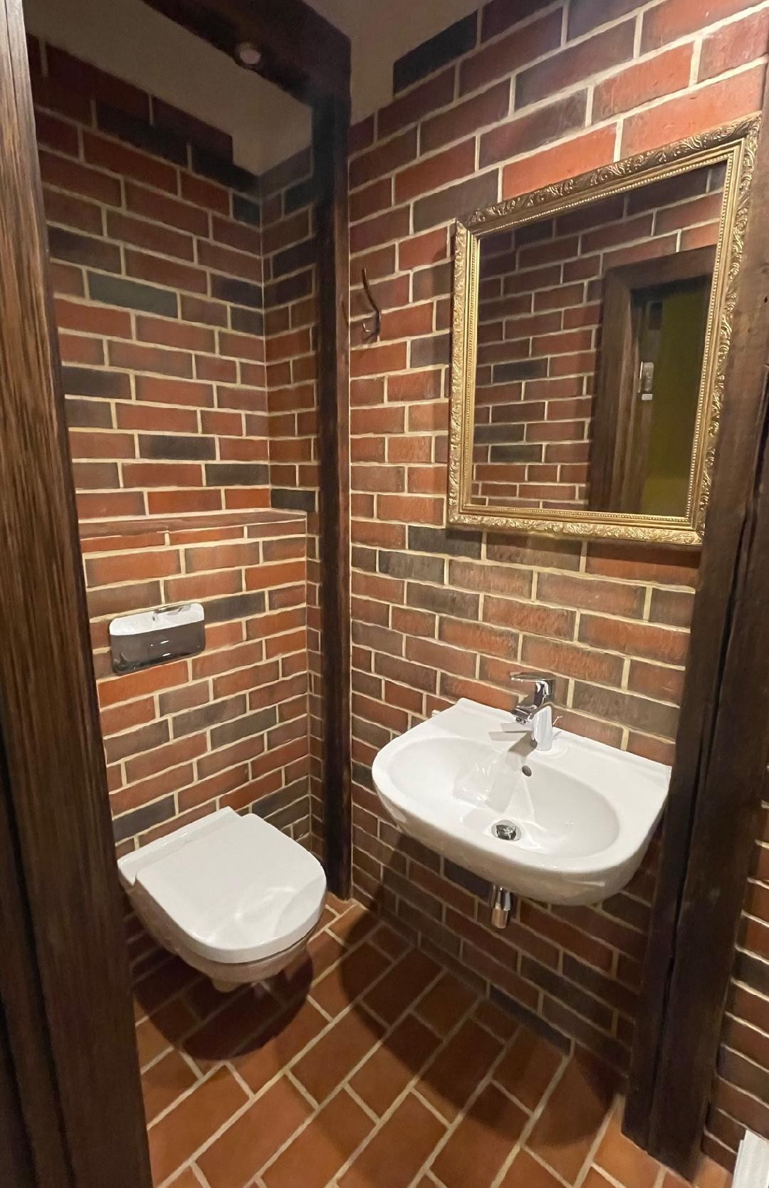 Compact bathroom with toilet and sink.