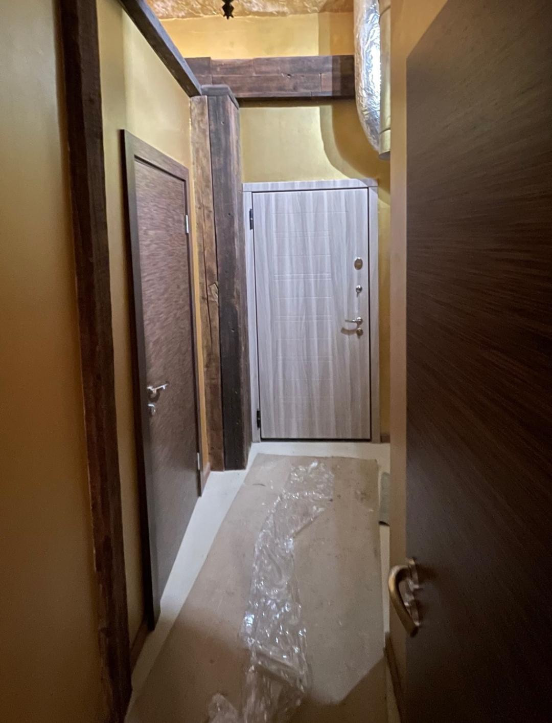 Narrow hallway with wooden doors.