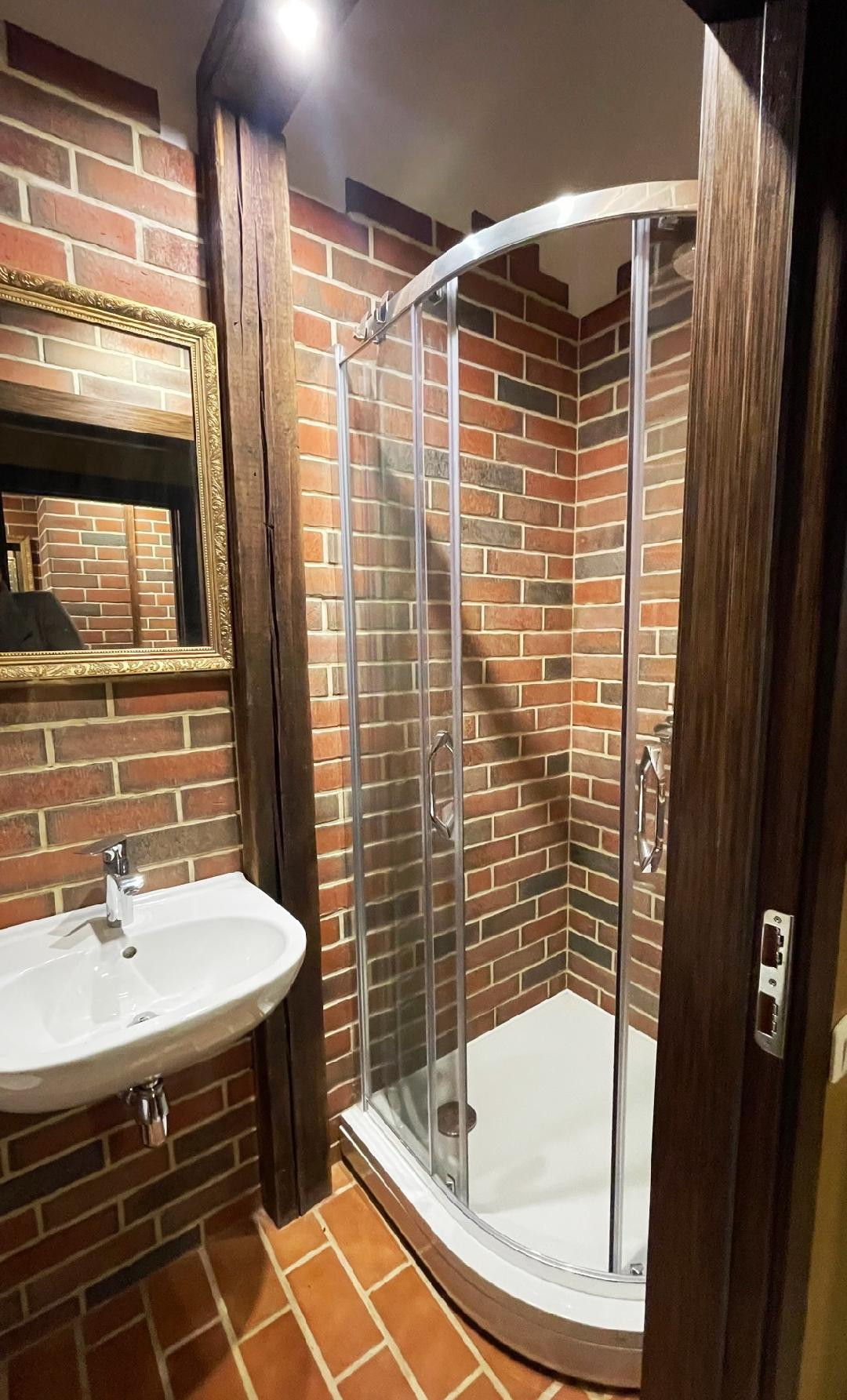 Bathroom with brick walls and shower.