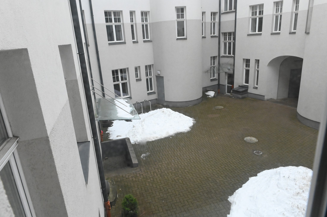 Ēkas iekšpagalms ar sniegu un ieejām.