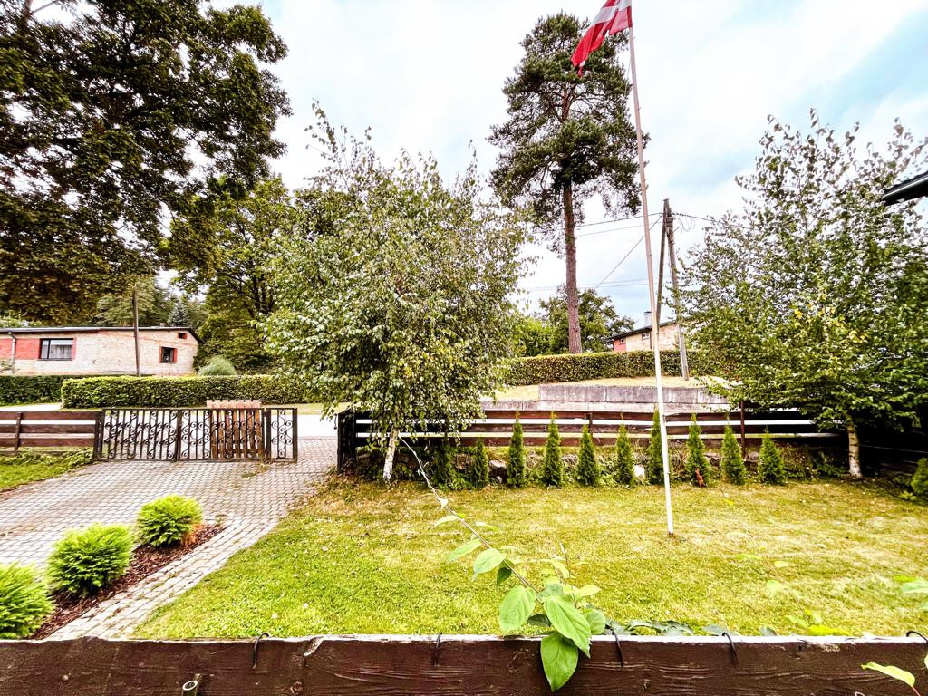 Yard with Latvian flag and trees