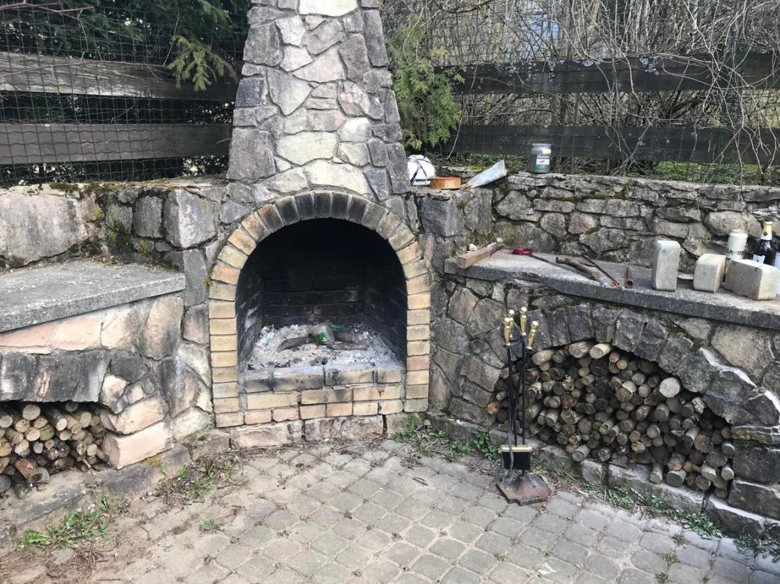 Stone outdoor fireplace and wood storage