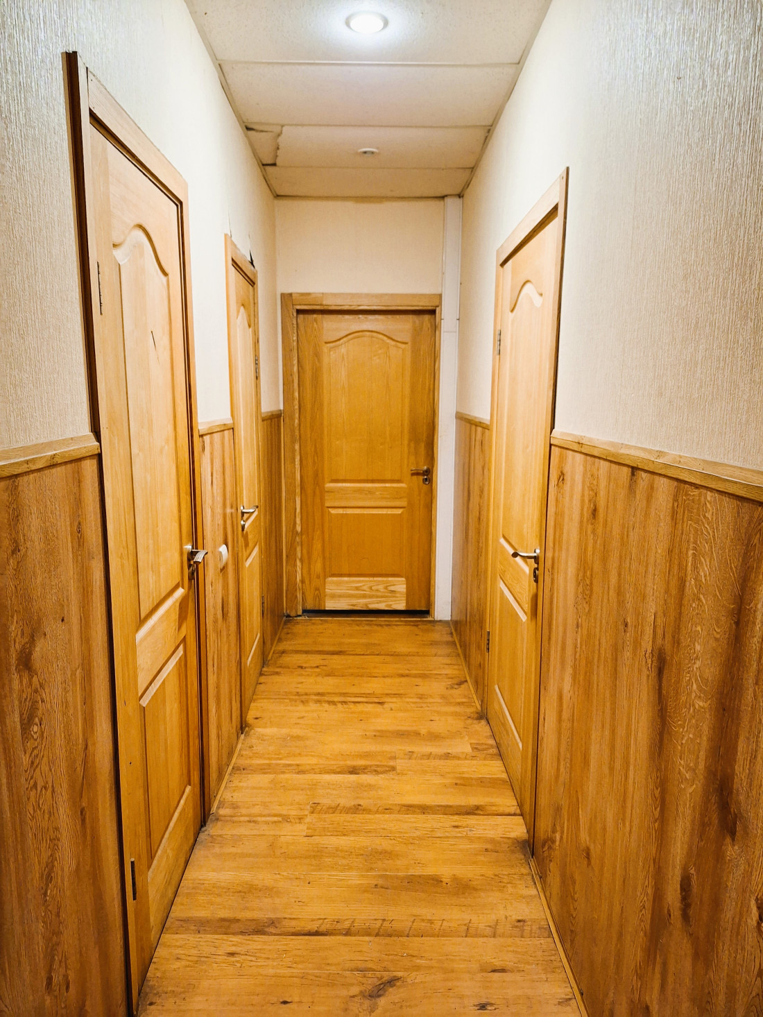 Corridor with wooden floors and doors.
