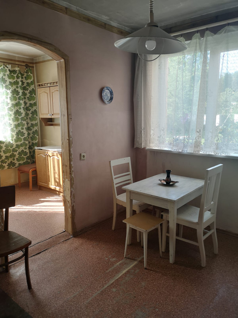 Virtuve ar galdu un krēsliem pie loga.