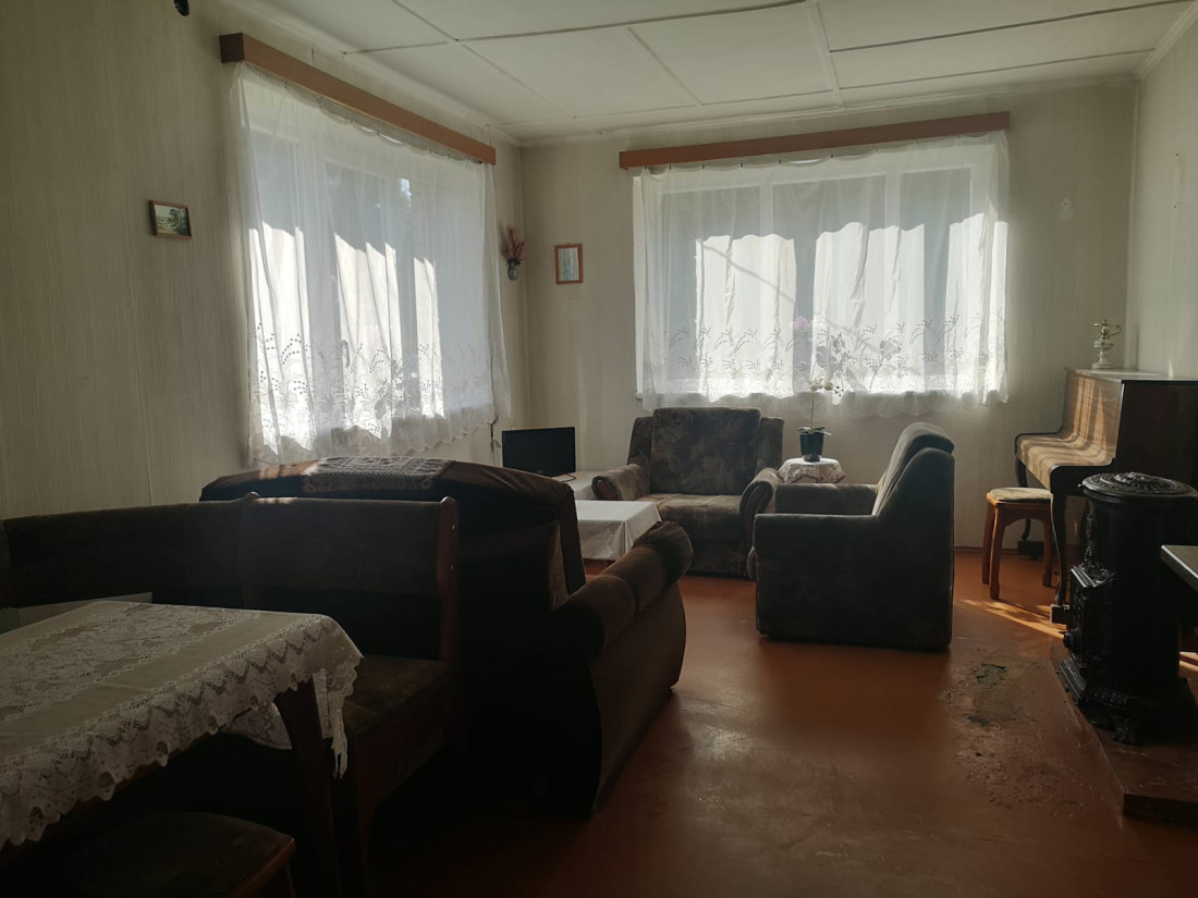 Plaša viesistaba ar dīvāniem un klavierēm.