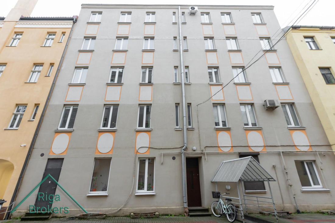 Ēkas fasāde ar oranžu apdari.