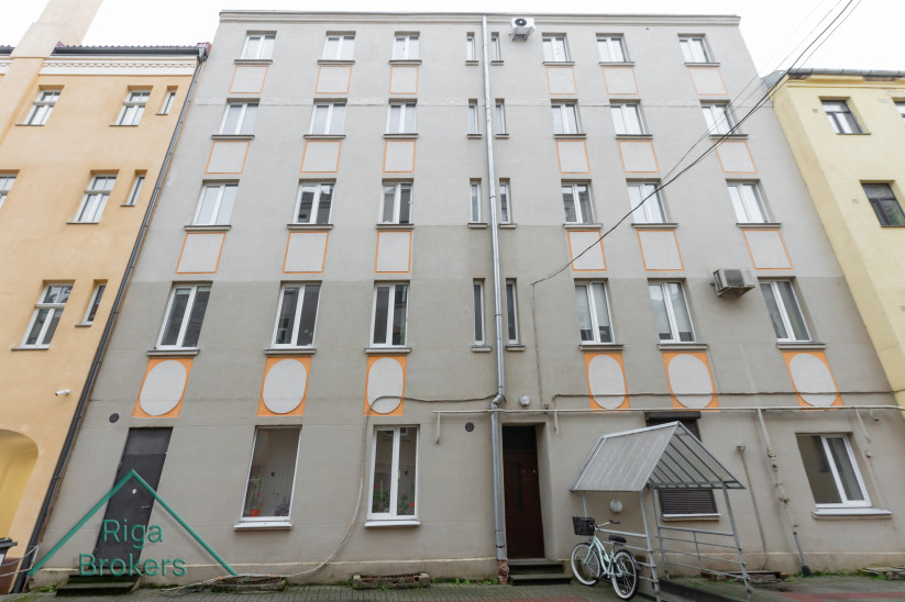 Ēkas fasāde ar oranžu apdari.