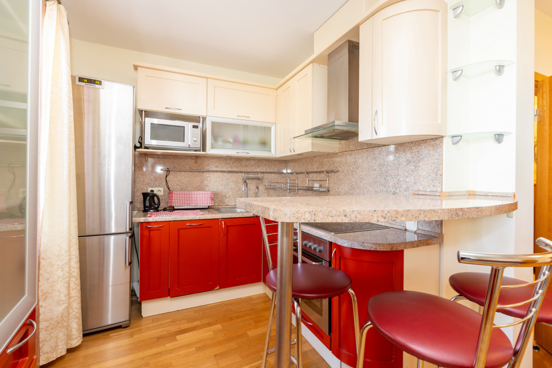Kitchen corner with cabinets and microwave.