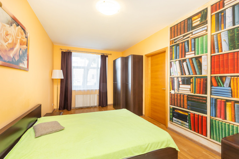 Bedroom with colorful bookshelf wall.