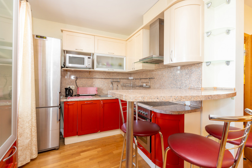 Kitchen corner with cabinets and microwave.