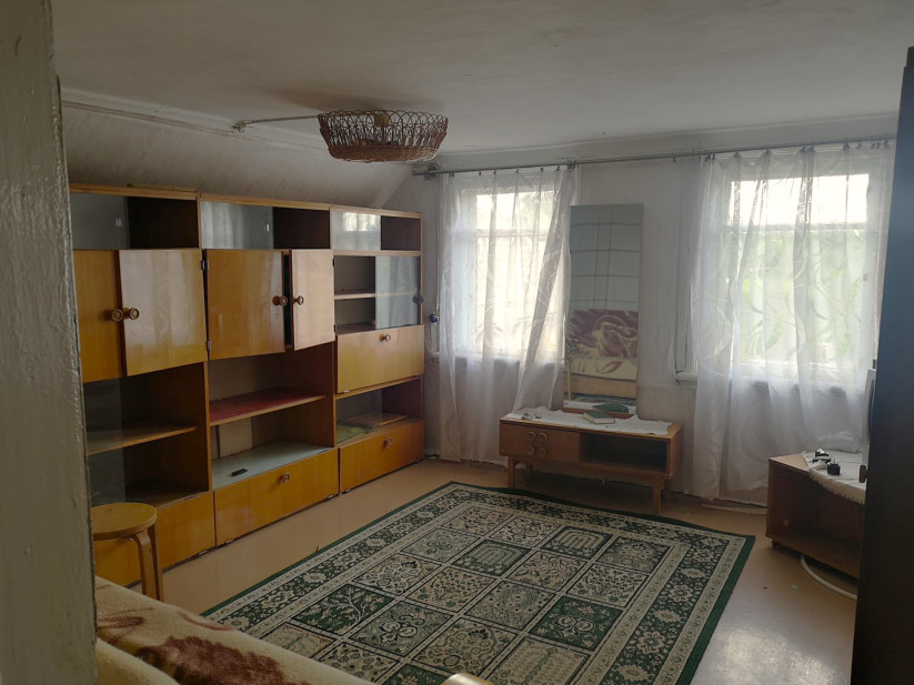 Plaša viesistaba ar mēbelēm un paklāju.