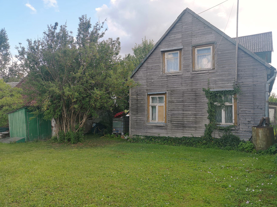 Veca māja ar dārzu priekšā.