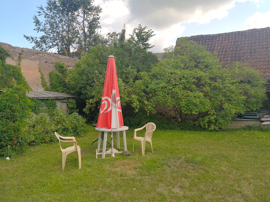 Dārzs ar galdiņu un krēsliem.