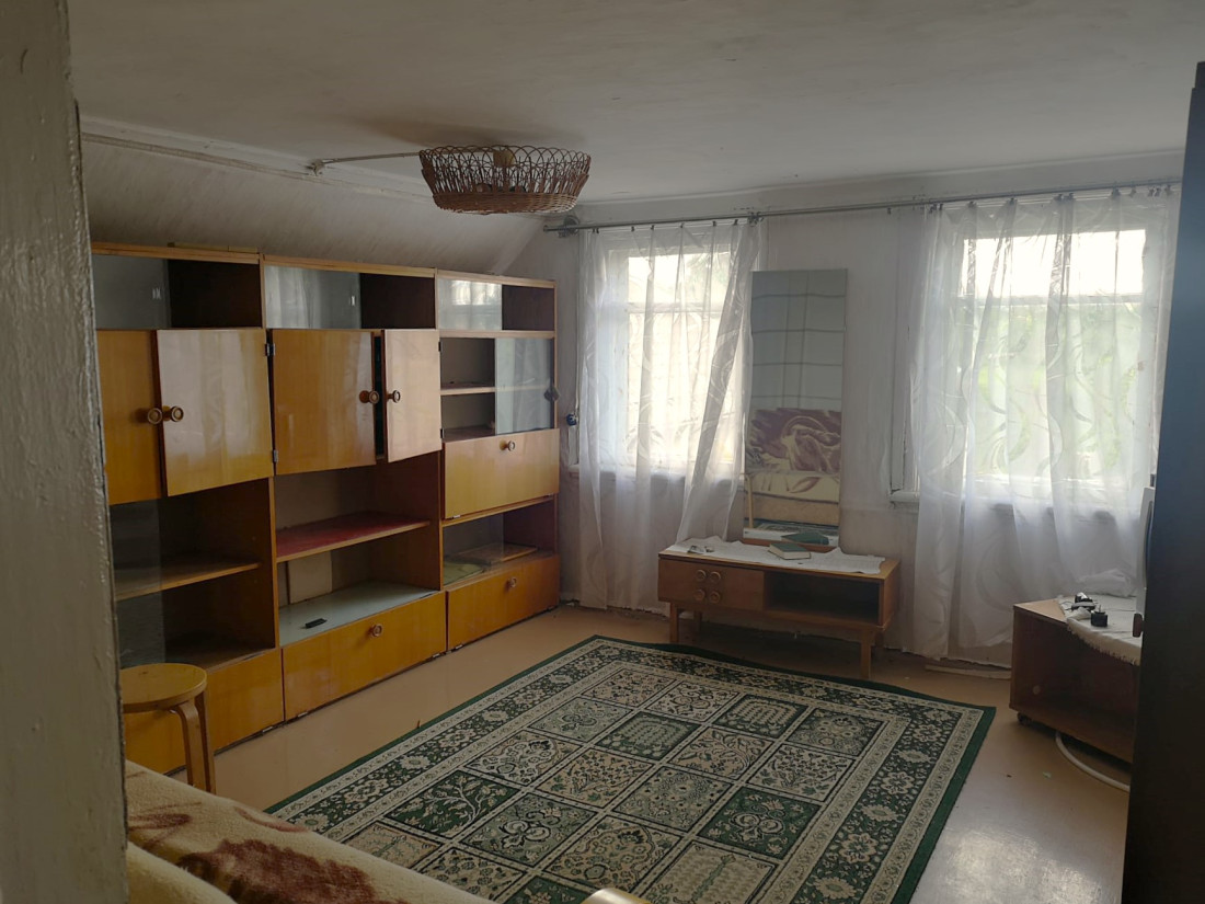 Plaša viesistaba ar mēbelēm un paklāju.