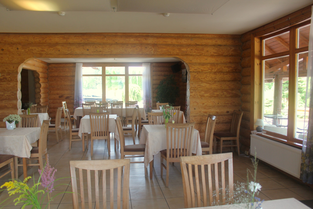 Wooden restaurant interior with tables.