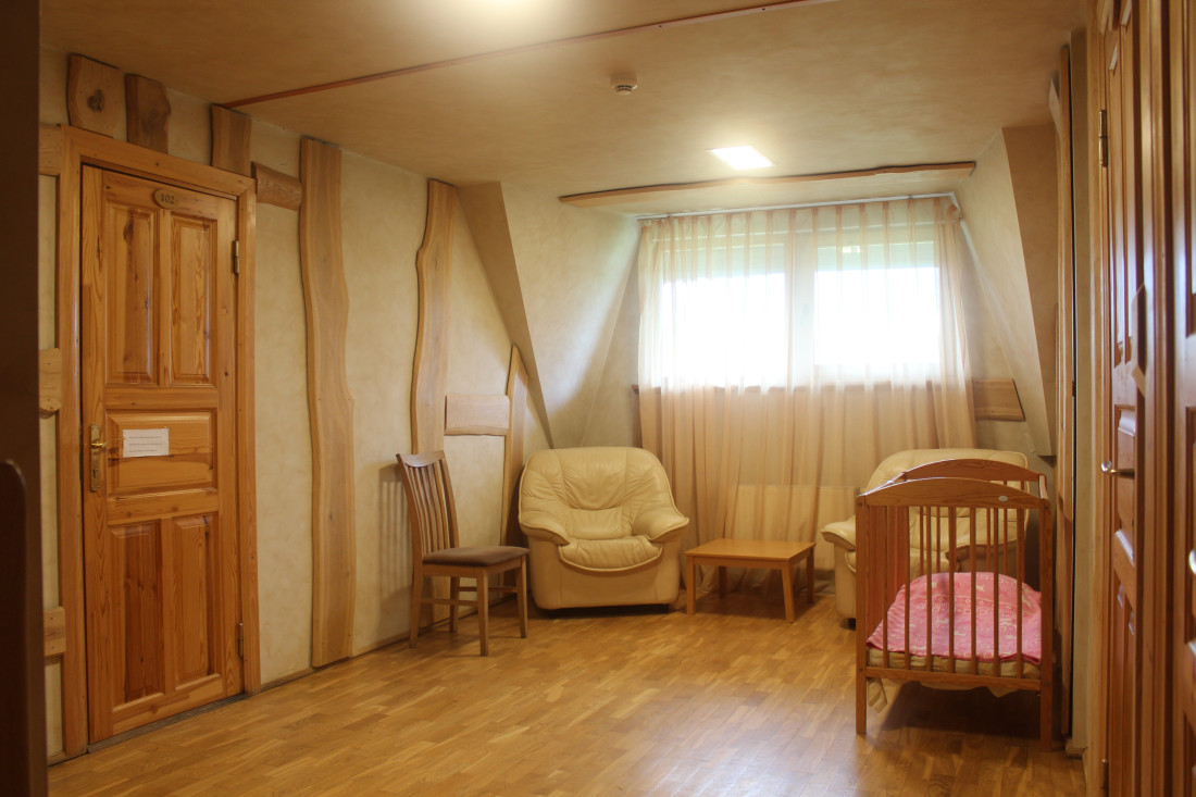 Room with crib and armchair.