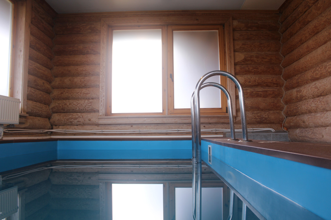 Indoor pool with wooden walls.