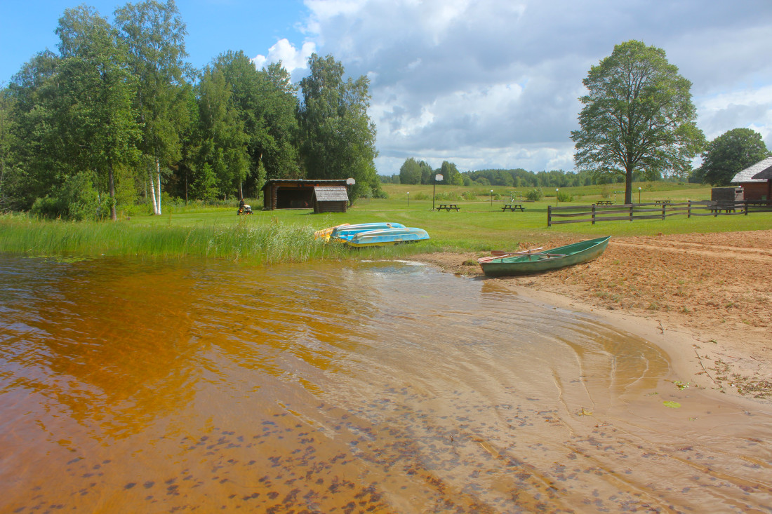 Sandy beach with boat near lake.