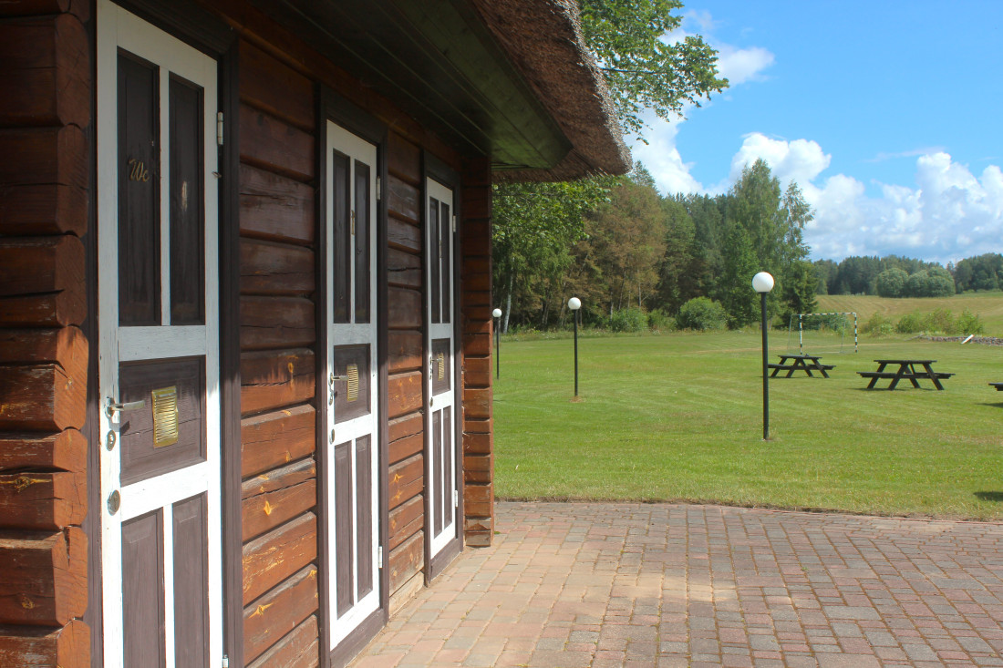 Wooden restroom doors and grass field.