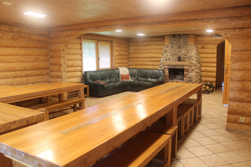 Wooden living room with fireplace and tables.