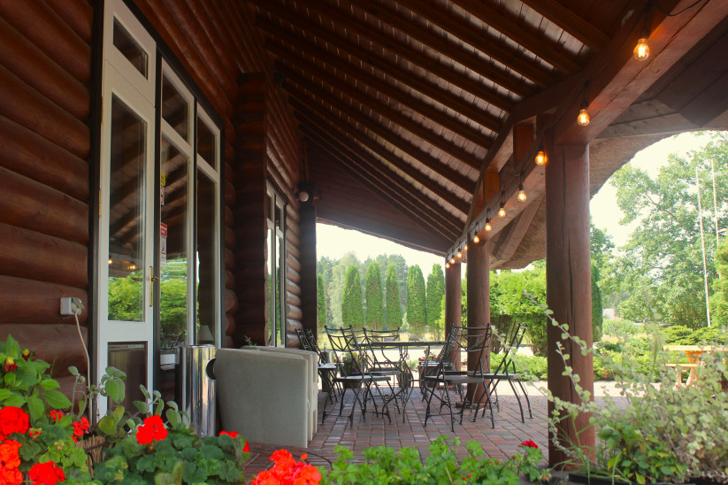 Comfortable terrace with wooden furniture and flowers.