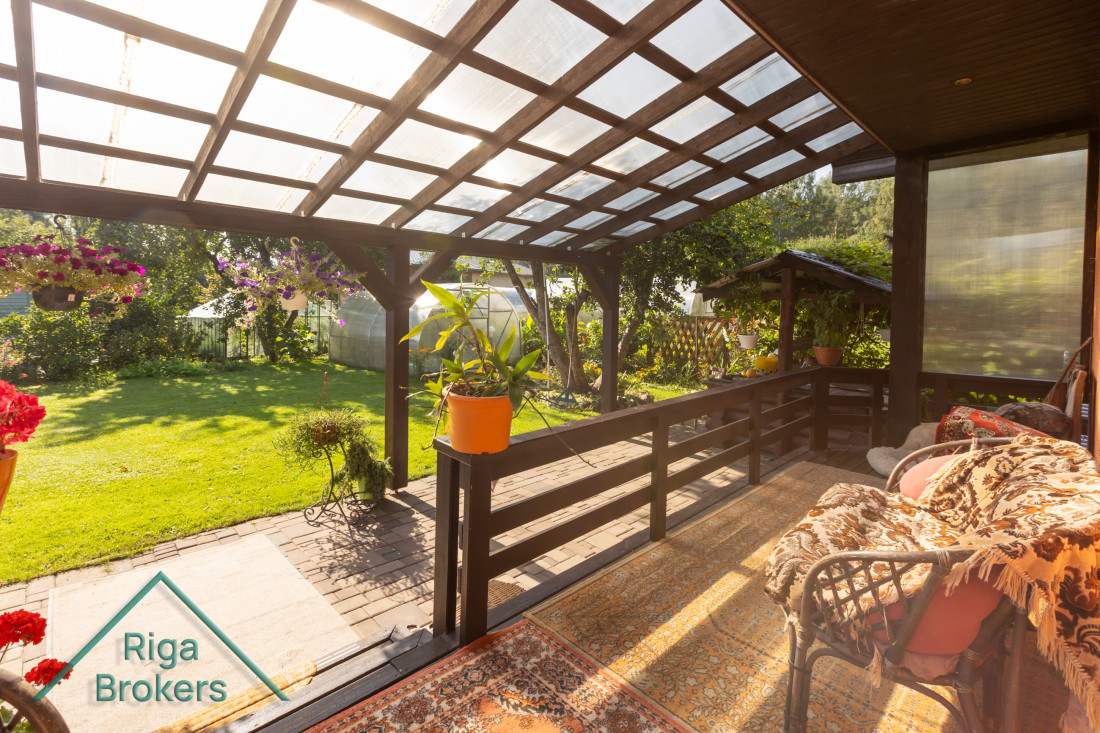 Veranda with flowers and green yard.