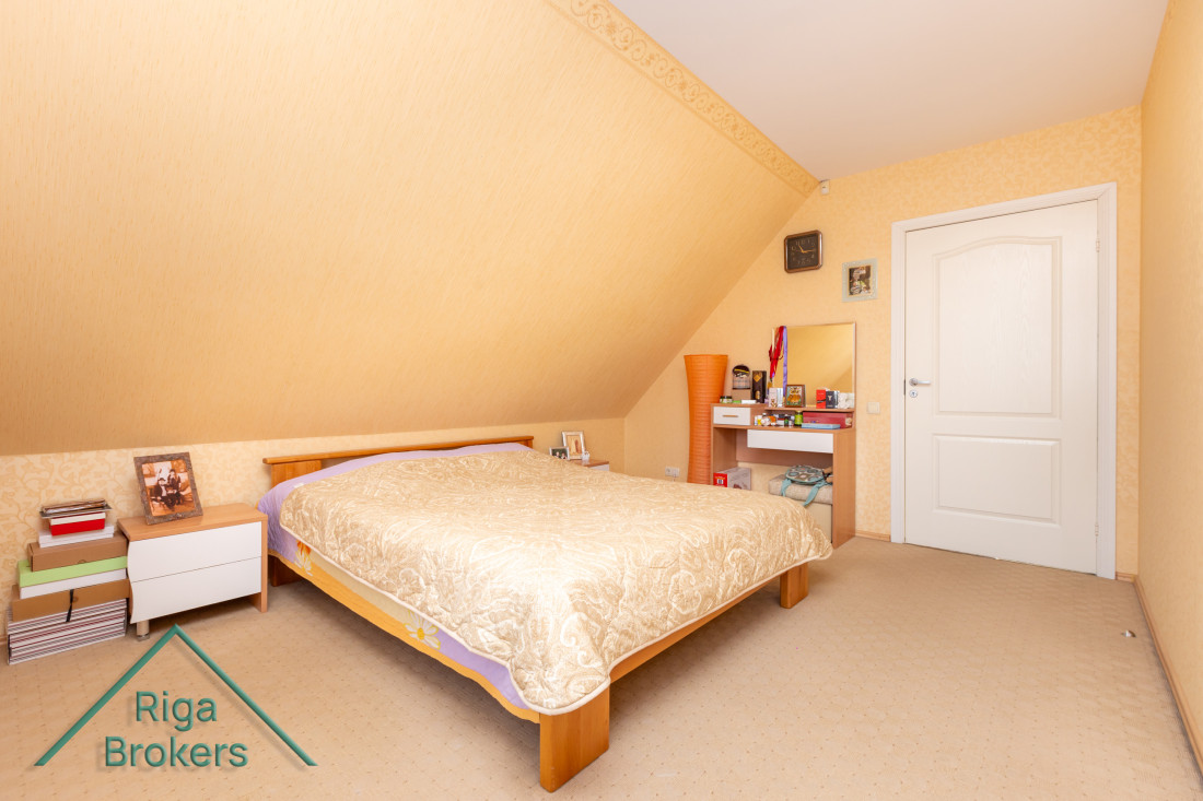 Bedroom with slanted ceiling and large bed.