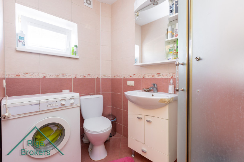 Compact bathroom with a washing machine.