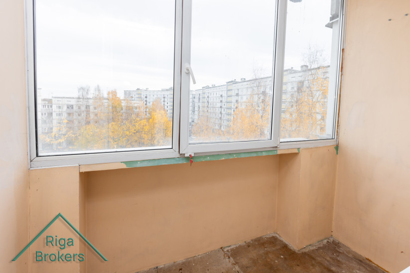 Balkona skats ar logu un rudenīgu ainavu.