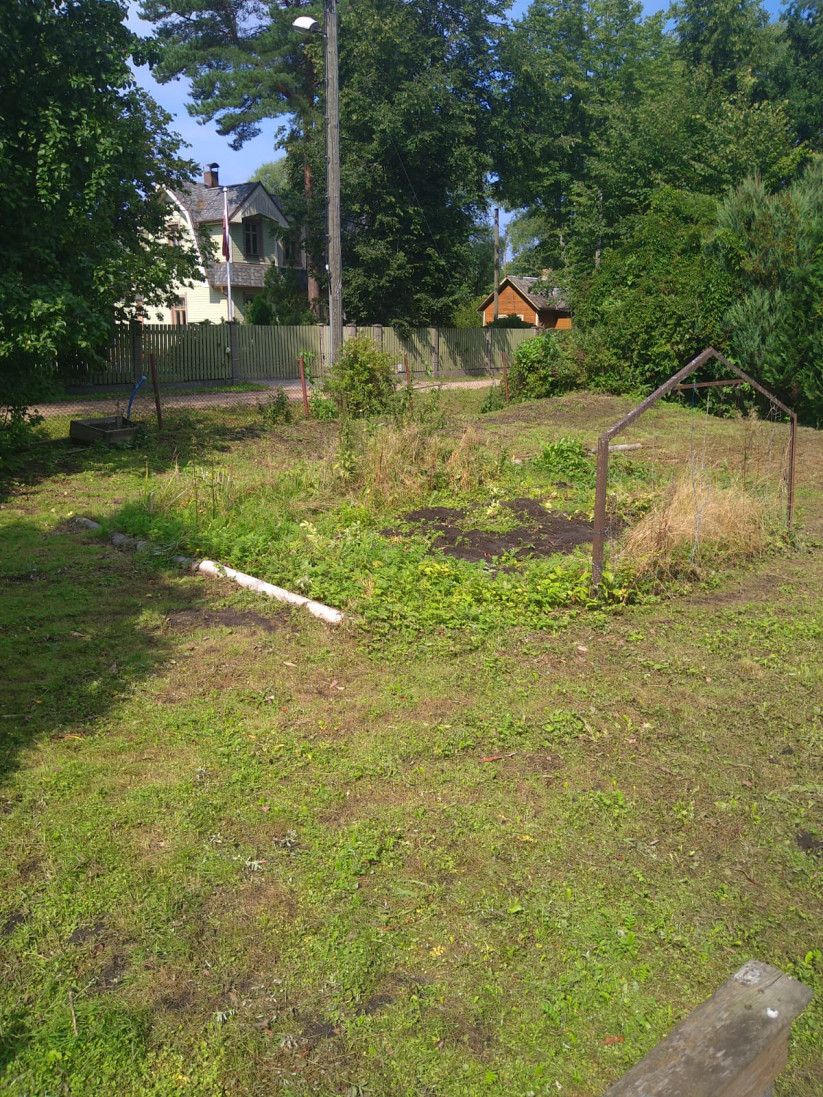Privāta pagalma skats ar māju fonā.