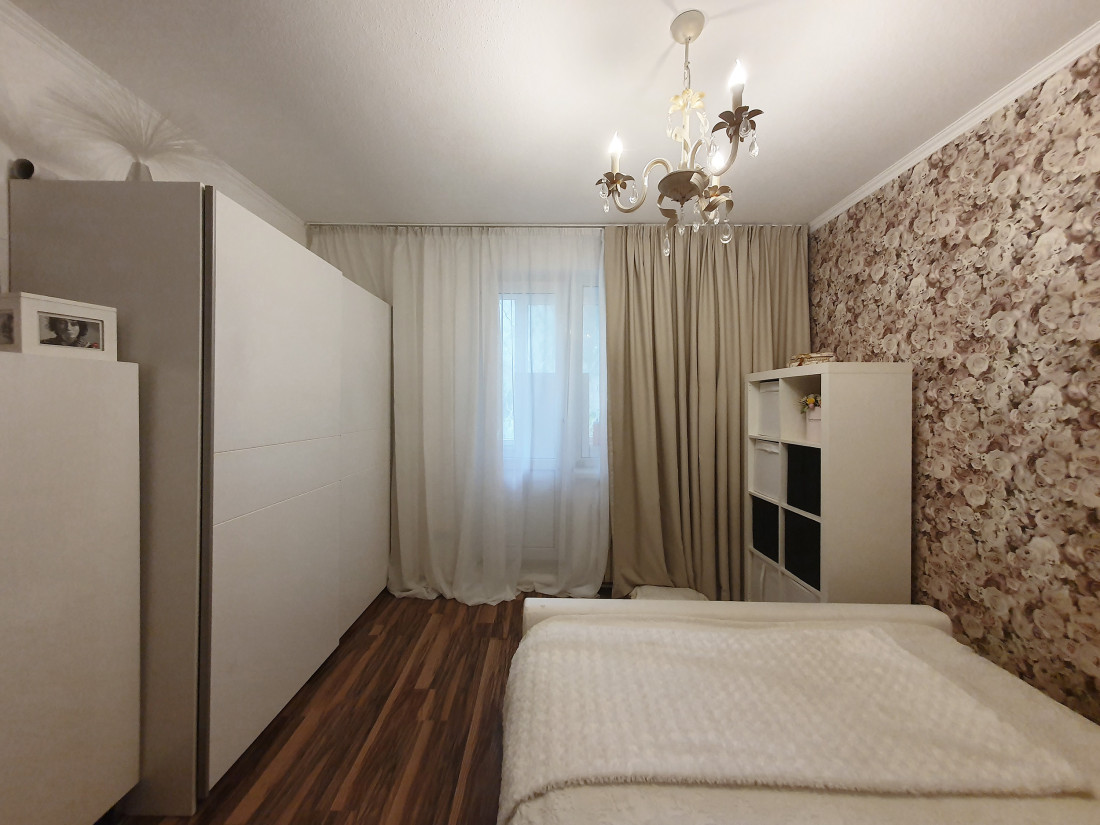 Eleganta guļamistaba ar gaišiem aizkariem.