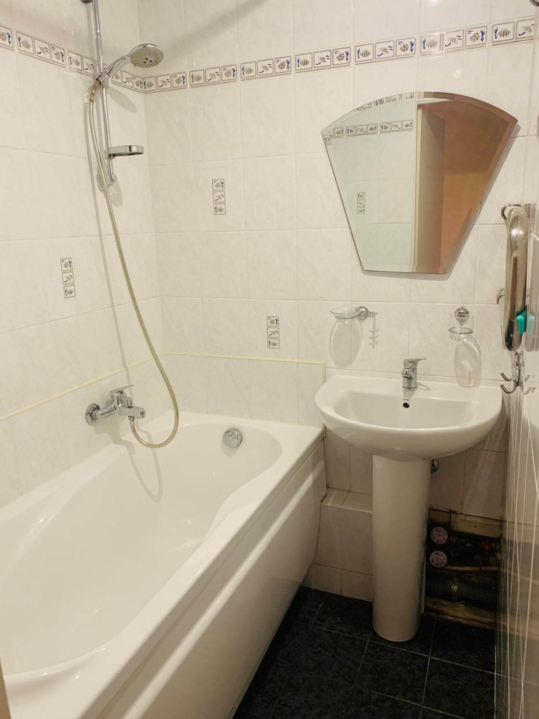 Bathtub with shower and sink.