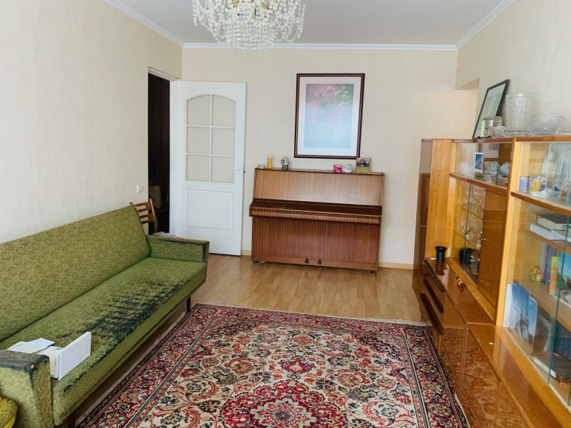 Living room with green sofa and piano.