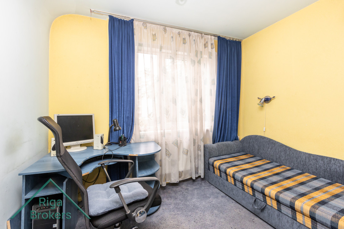 Room with a computer desk and curtains.