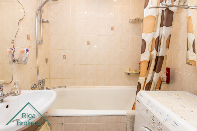 Bathroom with tiles and bathtub.