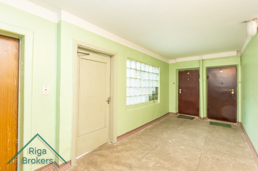 Hallway with green walls and doors.