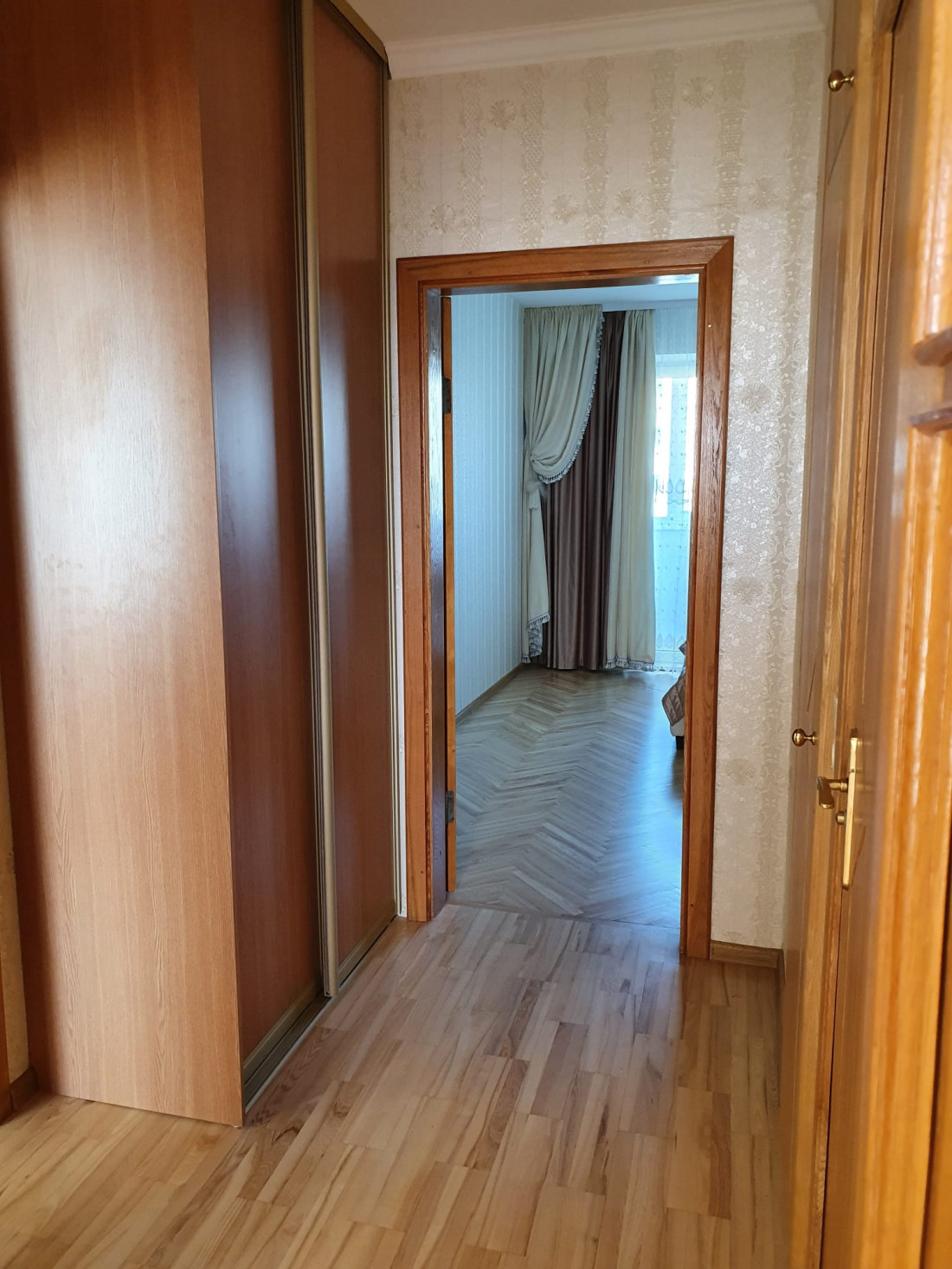 Corridor with parquet flooring and bedroom view.