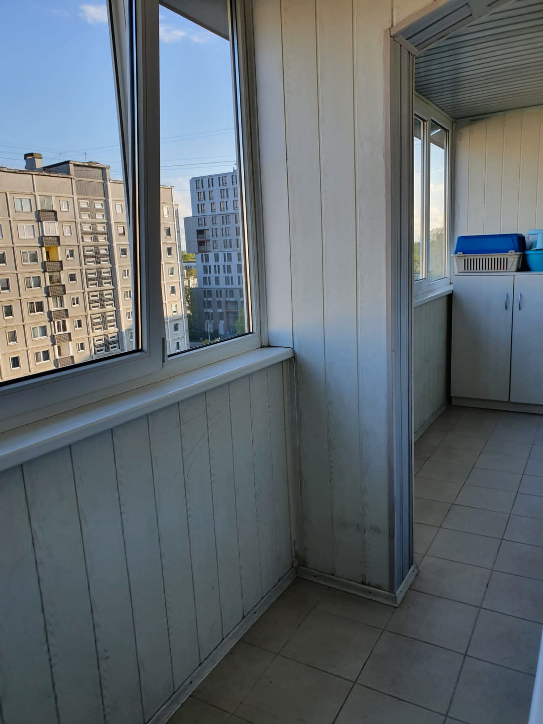 Balcony with glazed panels and city view.
