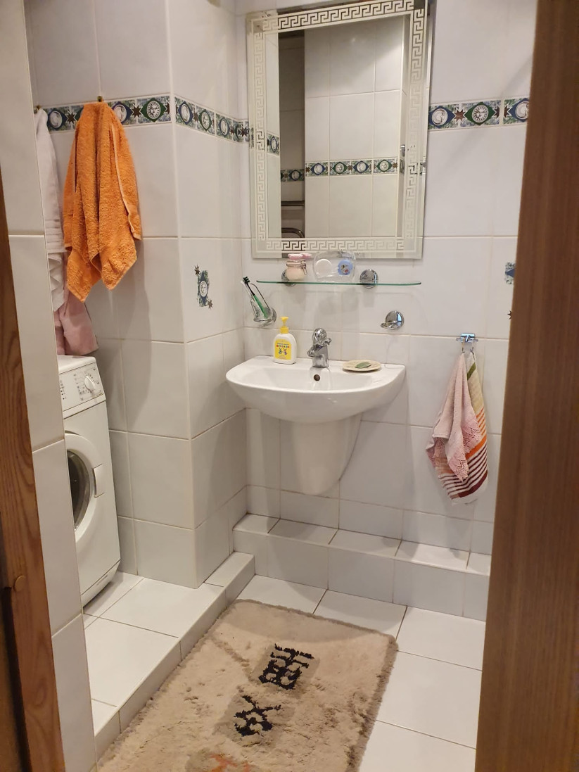 Bathroom with a washing machine and mirror.