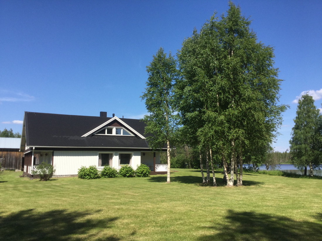 Māja ar baltām sienām un pagalmu.