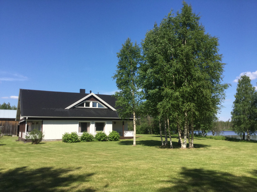 Māja ar baltām sienām un pagalmu.