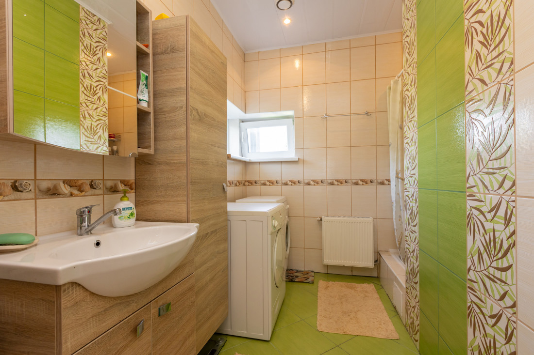 Bathroom with green and beige tiles.