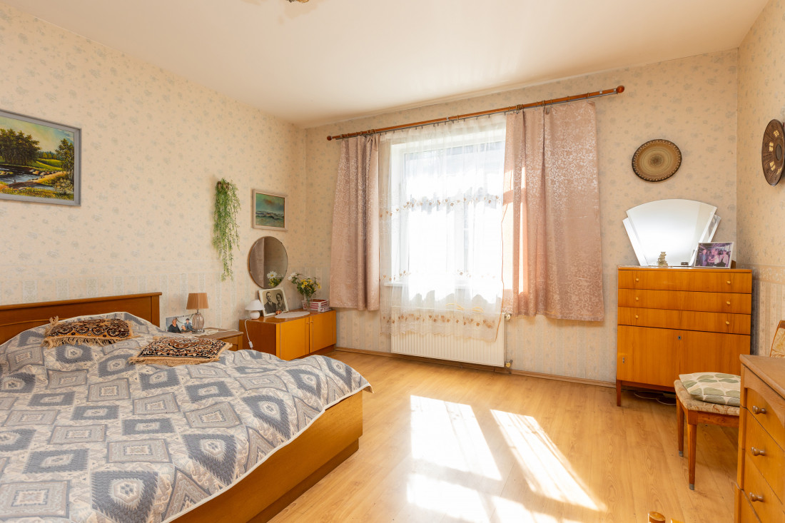 Bedroom with large window and furniture.