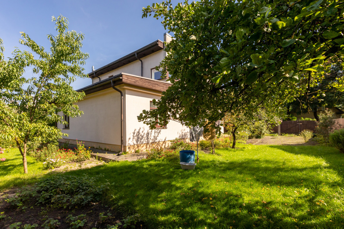 House with green yard and trees.