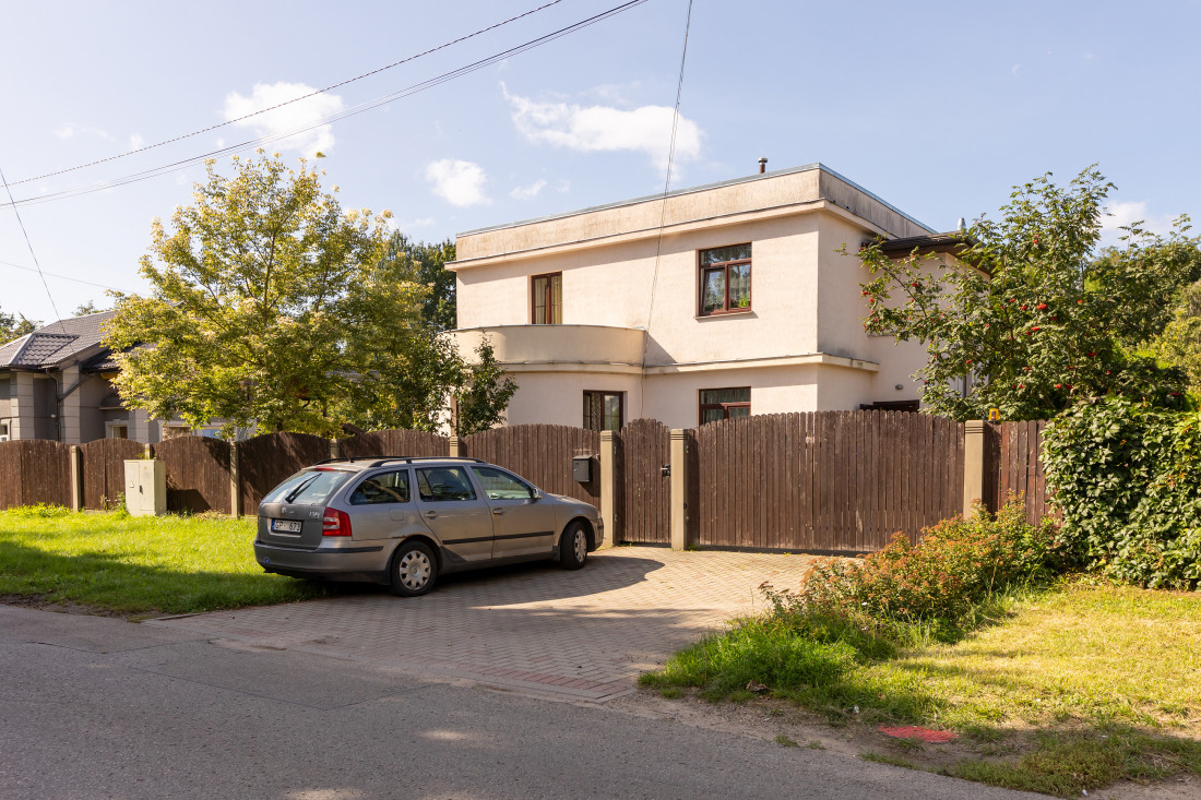 House facade with driveway and car.