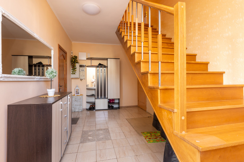 Hallway with wooden stairs and mirror.