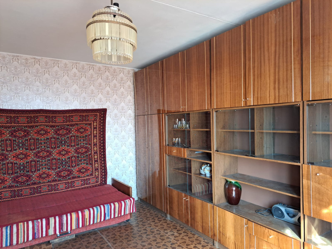 Living room with wooden furniture and rug.