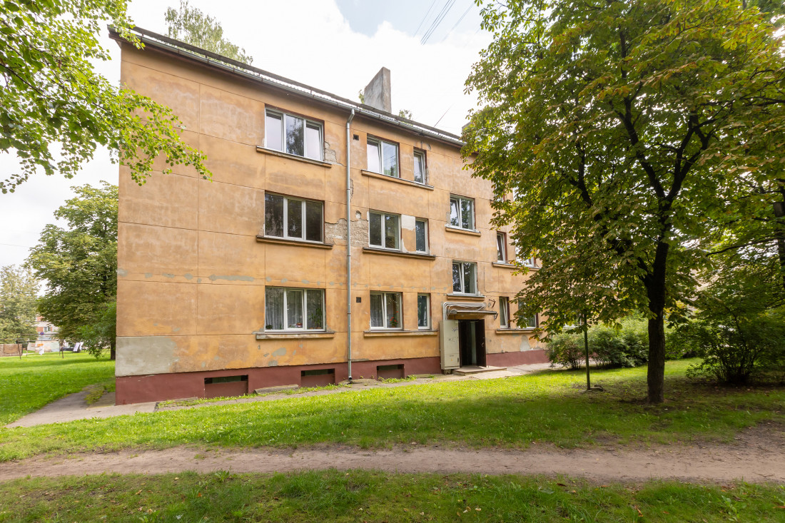 Ārējais skats uz dzeltenu ēku.