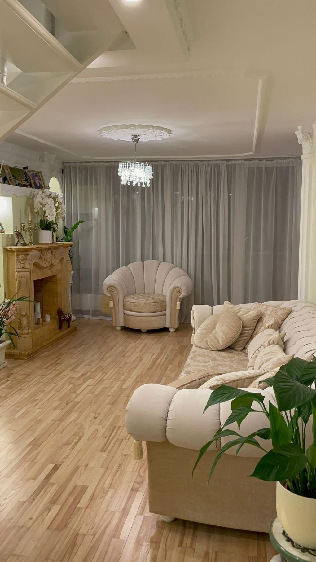 Eleganta viesistaba ar kamīnu un gaišām mēbelēm.