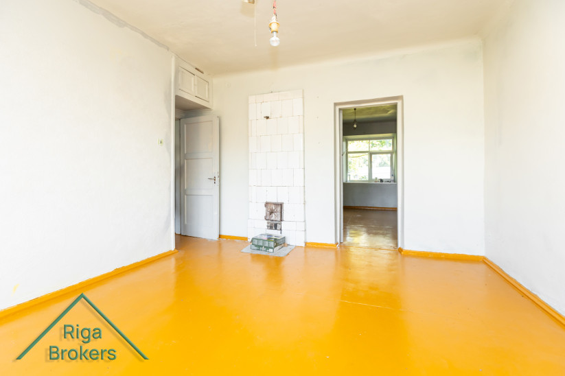 Room with two doors and a tiled stove.